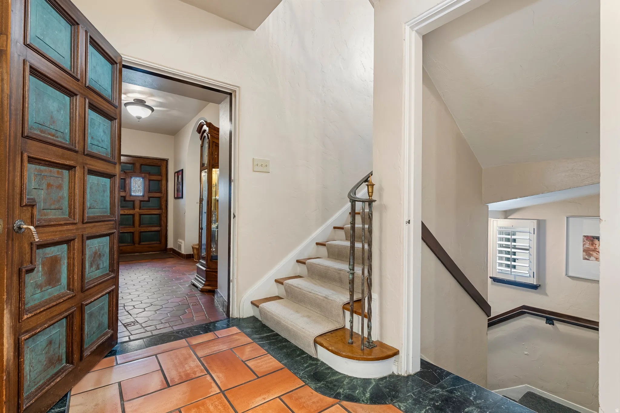 Foyer entrance with stairs and stone tile floors