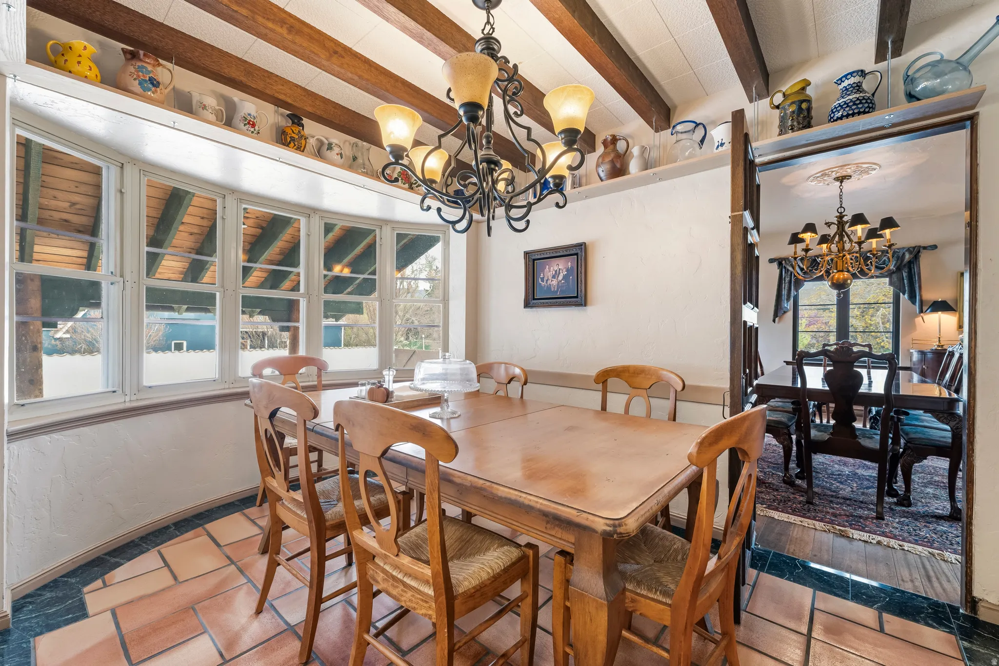 Dining room with suspended lighting and beam ceiling