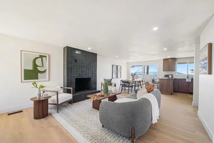 Living room with light wood-type flooring, a fireplace, and recessed lighting