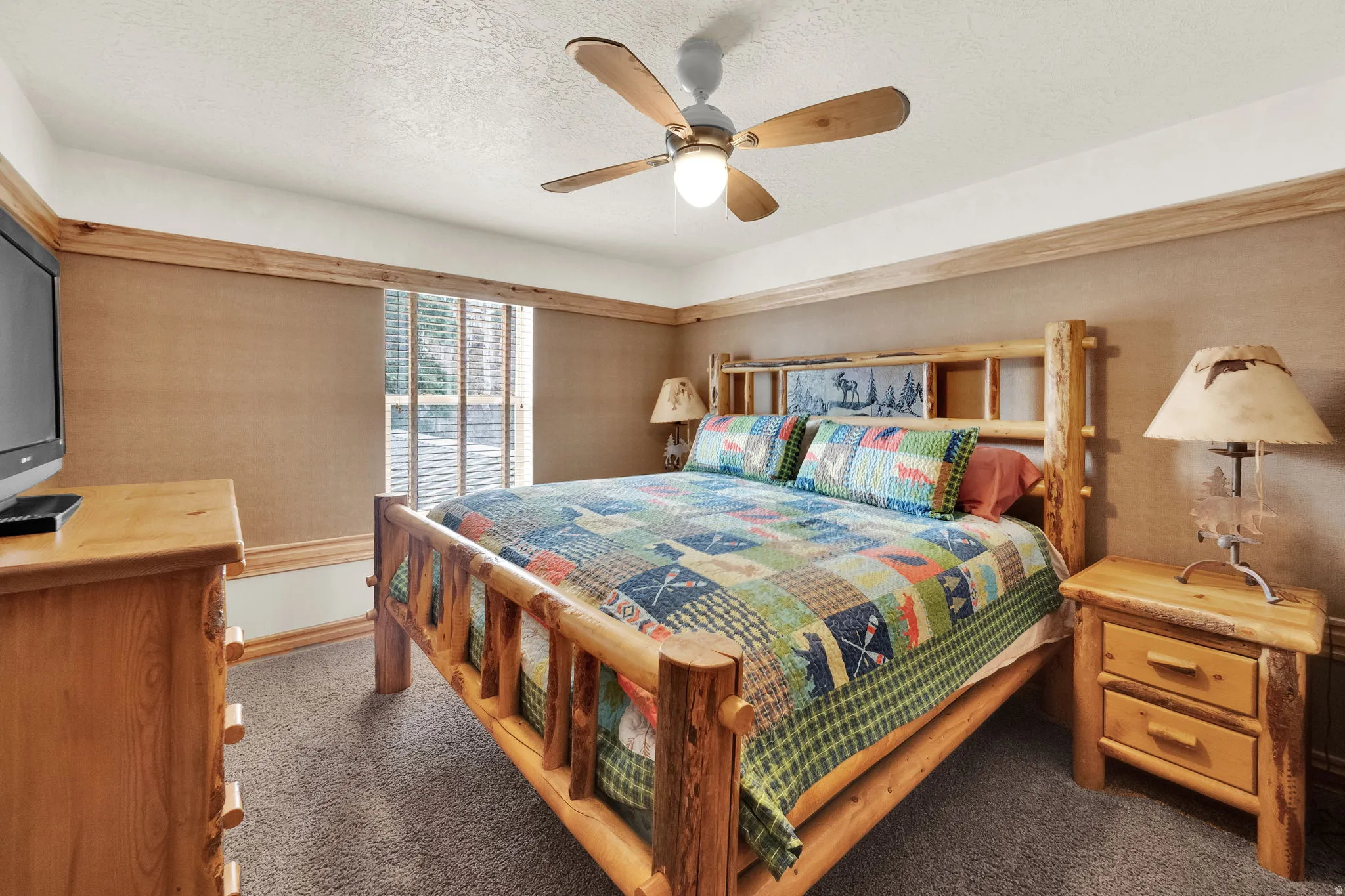 Bedroom featuring dark colored carpet, ceiling fan, and a textured ceiling