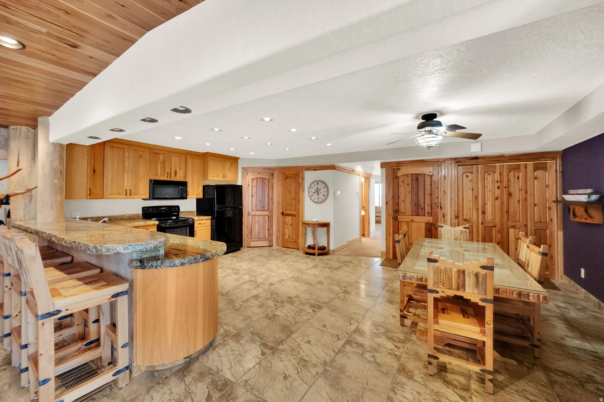 Kitchen featuring black appliances, a peninsula, recessed lighting, a breakfast bar area, and ceiling fan