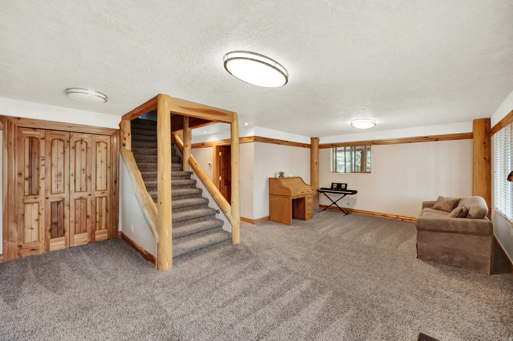 Below grade area featuring a textured ceiling and carpet