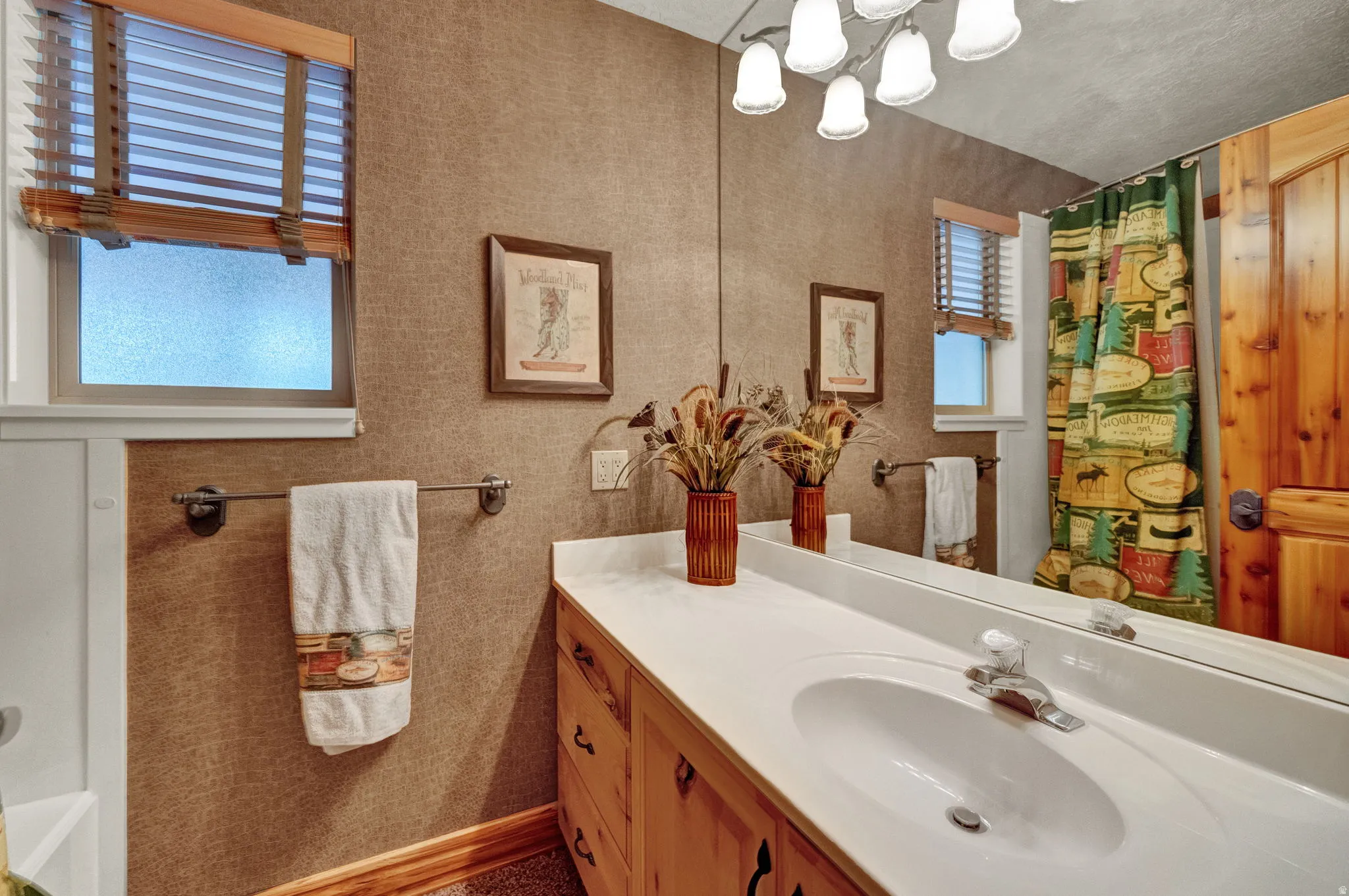 Full bathroom featuring vanity, curtained shower, and suspended lighting