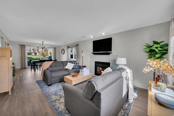 Living room featuring suspended lighting, a tile fireplace, and dark wood-style flooring
