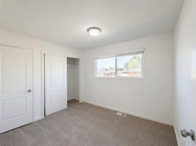 Unfurnished bedroom featuring carpet floors and a closet
