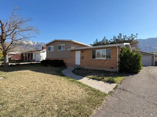 Split level home with a mountain view, brick siding, a front lawn, and crawl space