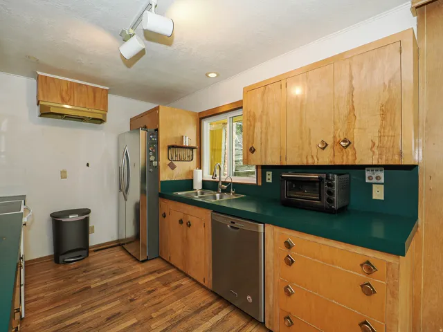 Kitchen with stainless steel appliances, dark wood-style floors, dark countertops, and a textured ceiling