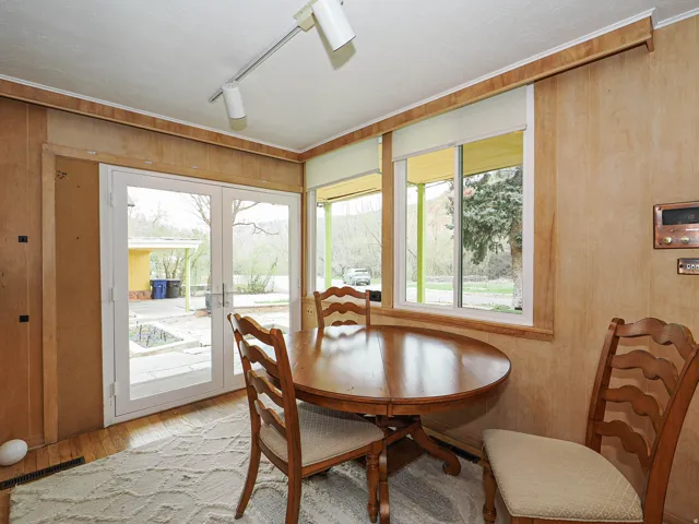 Dining space featuring rail lighting, wooden walls, and light wood finished floors
