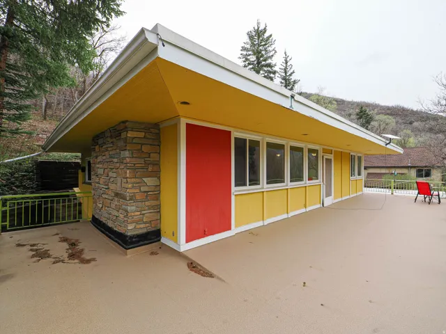 View of home's exterior with stone siding and a patio area