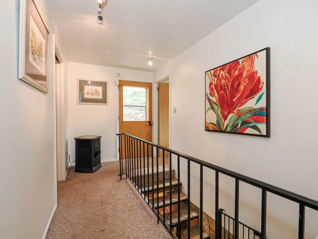 Corridor with an upstairs landing and light colored carpet