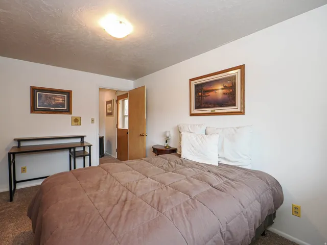 Carpeted bedroom featuring baseboards and a textured ceiling