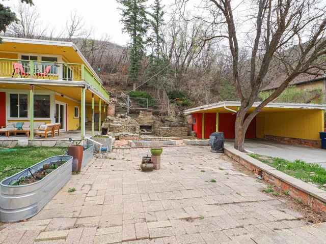 View of patio with an outdoor living space with a fireplace, a garden, and grilling area