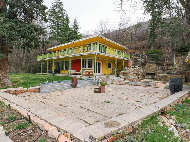 View of front of property featuring a front yard, a patio, and a large porch