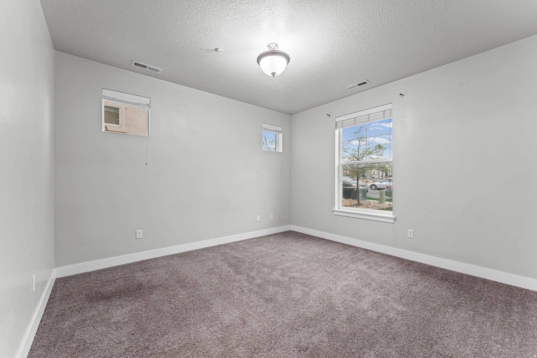 Carpeted empty room featuring a textured ceiling