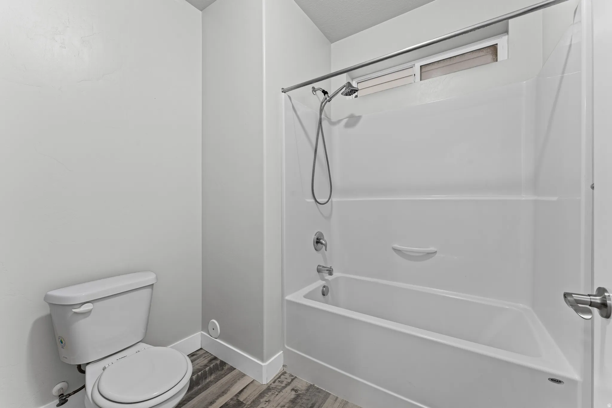 Full bath with light wood-style flooring and bathing tub / shower combination