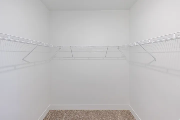 White wire shelving system, light-colored carpeting, white wall paint