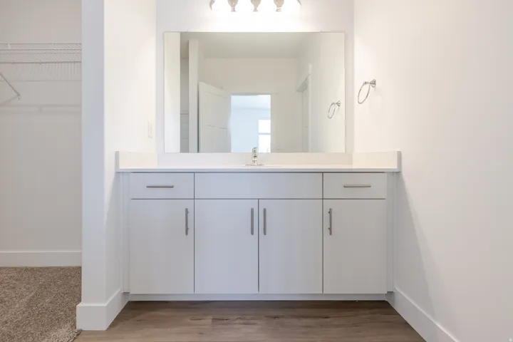 White vanity with a light-toned countertop and an integrated sink