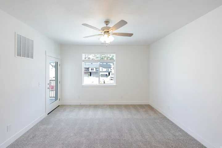 Recessed ceiling fan with light fixture, carpeted flooring, large window, and a glass-paneled door