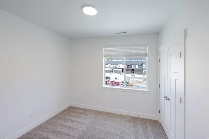 Recessed ceiling lighting, window with blinds, wall-to-wall carpeting, and white paneled doors