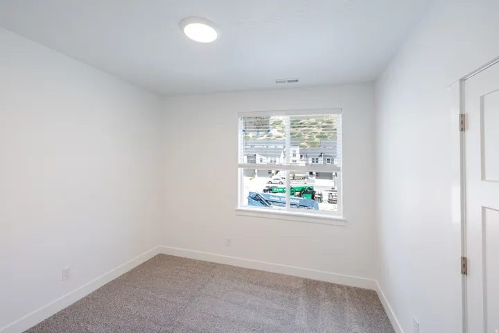 Neutral wall paint, recessed ceiling lighting, window with blinds, panel door, and carpet flooring