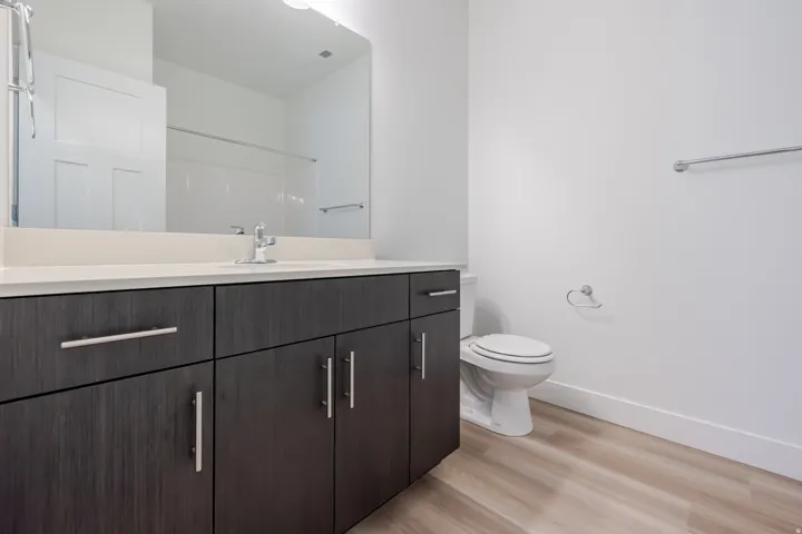 Bathroom featuring a vanity with dark wood-finish cabinetry, a light-colored countertop, and a large mirror