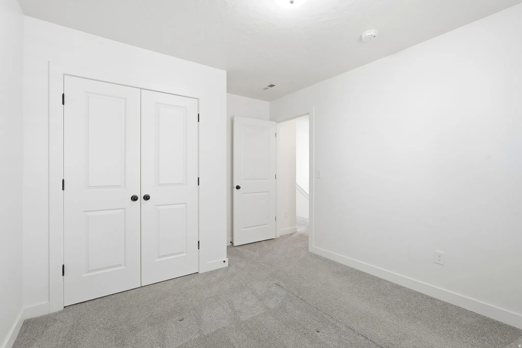 Room featuring light gray carpet, white walls, and white trim