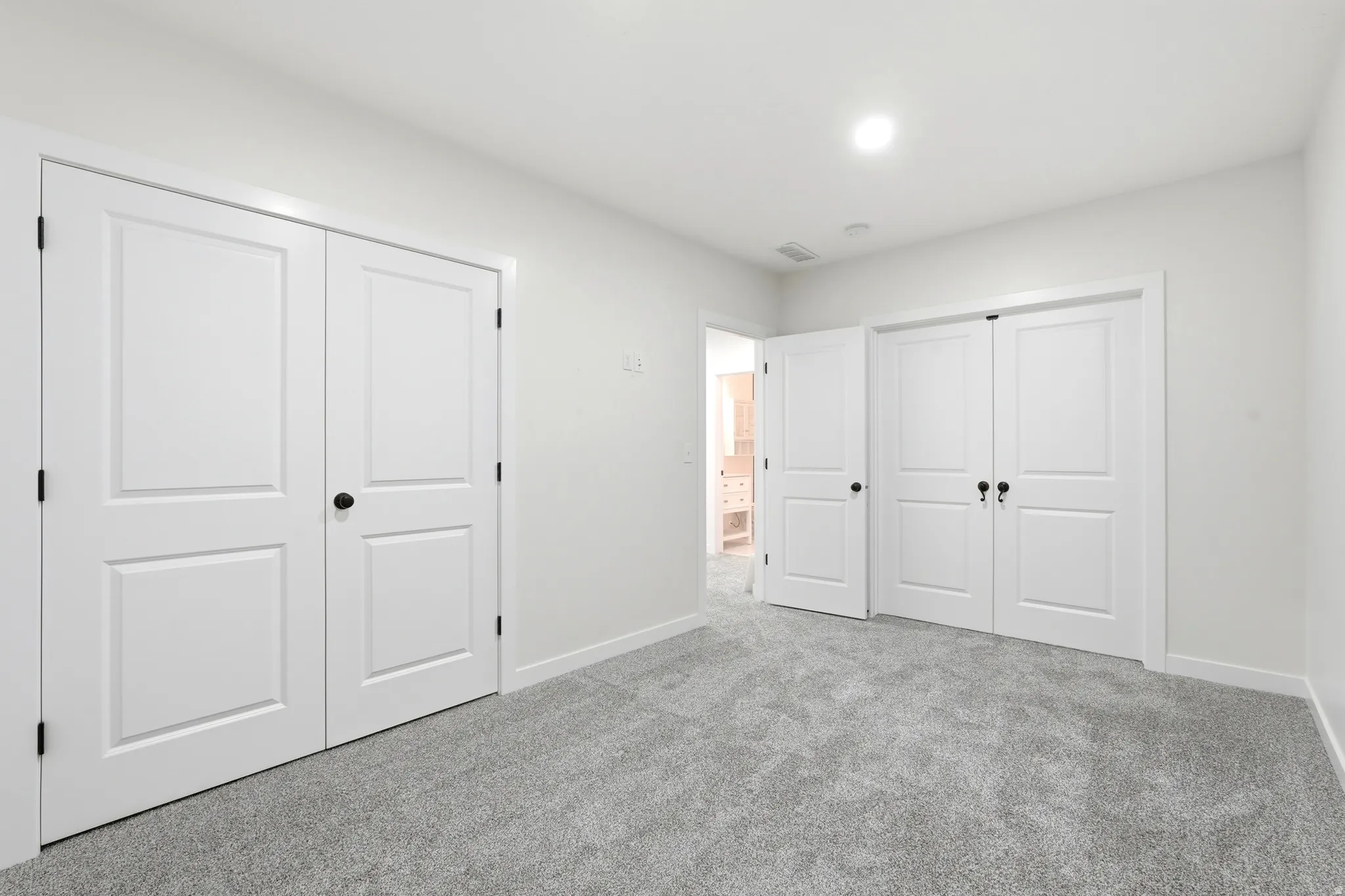 Neutral-toned carpeting paired with crisp white walls and baseboards