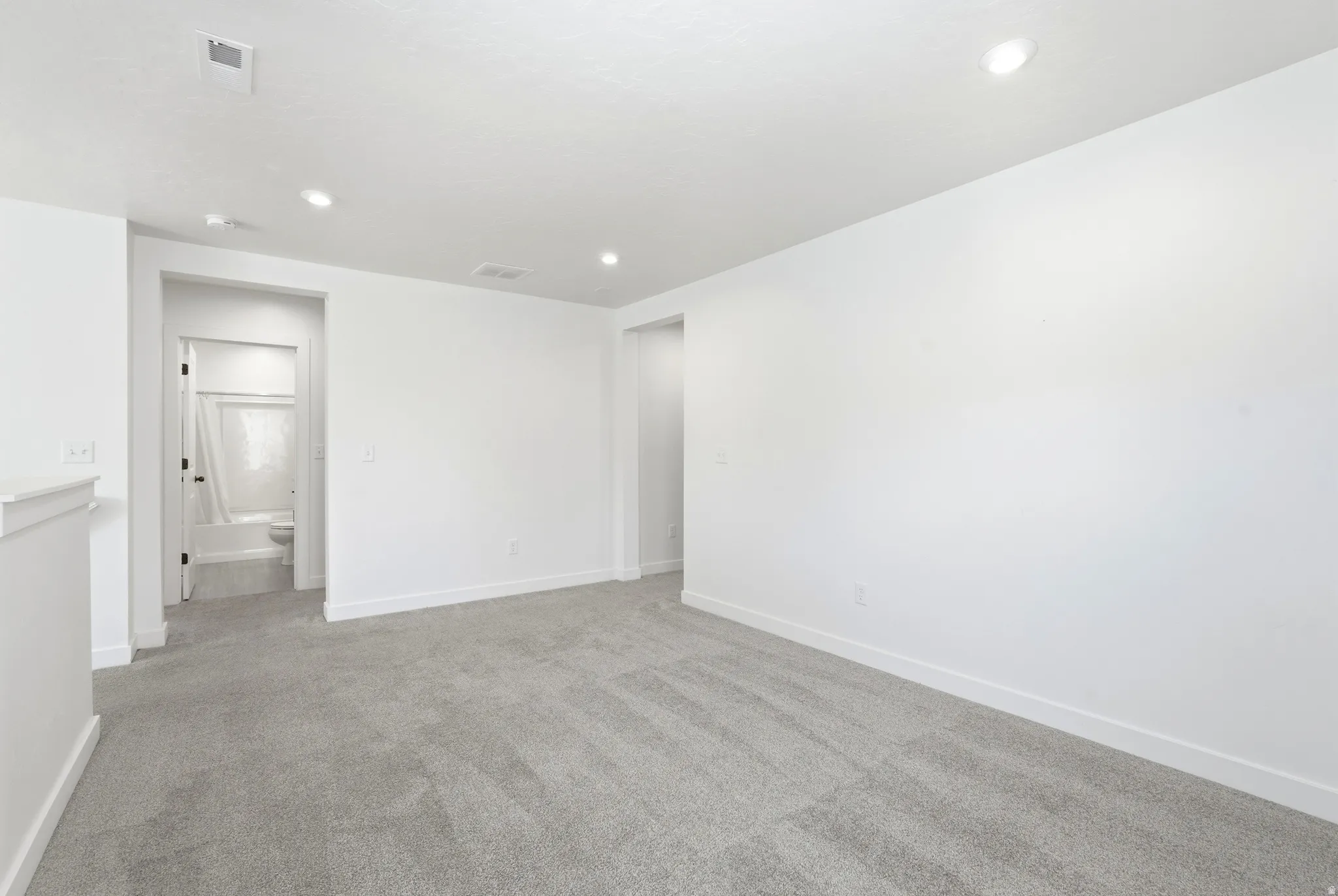 Carpeted room featuring recessed lighting, bright white walls, and white trim
