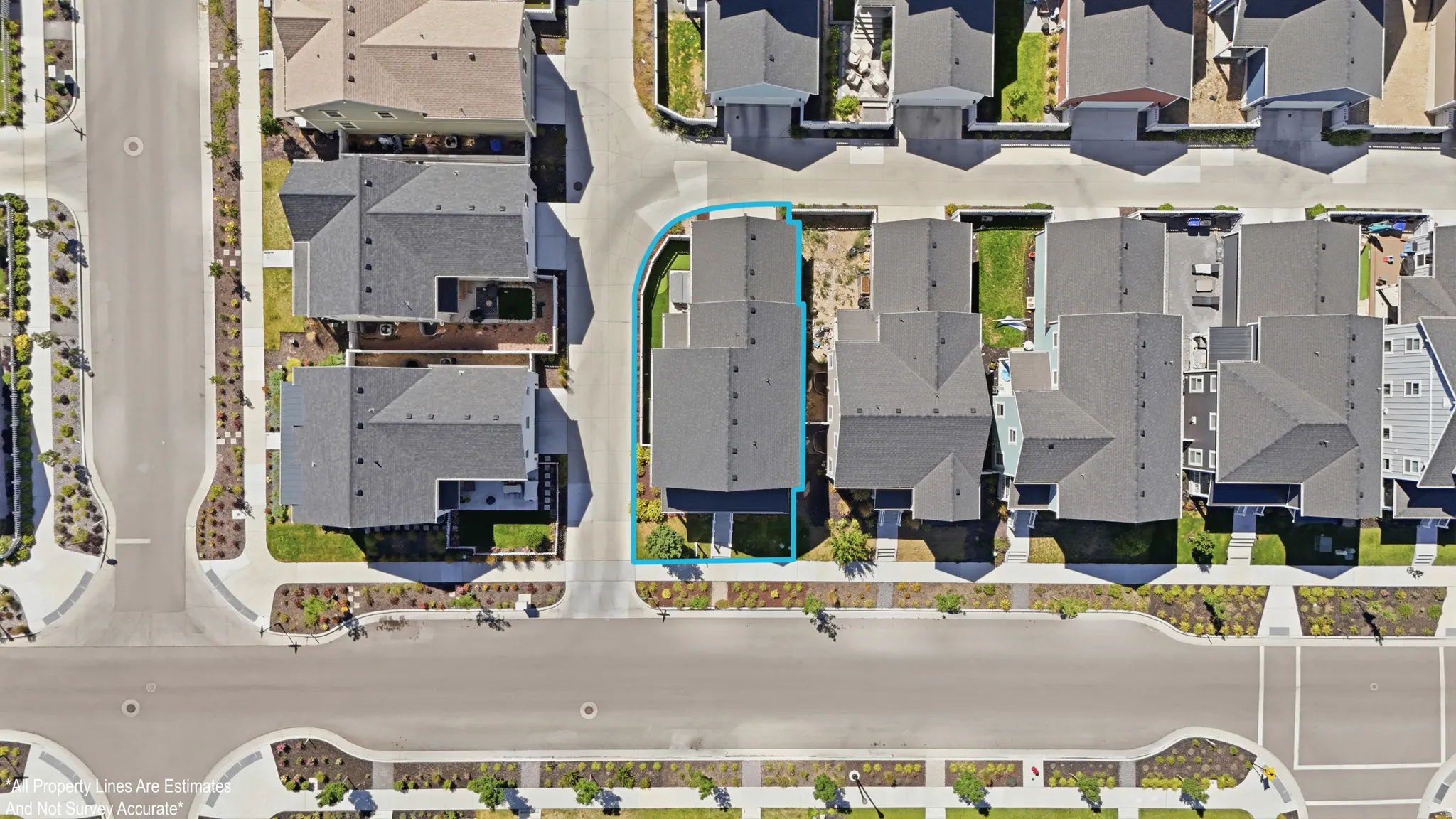 Aerial view of a residential property with a dark gray roof, situated on a corner lot
