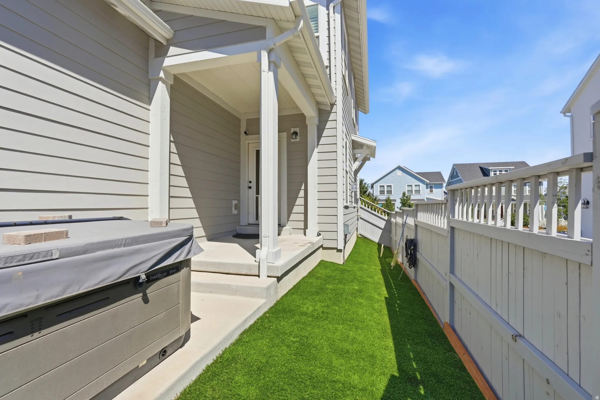 Covered porch entry featuring white columns, a neutral-toned exterior, and concrete steps