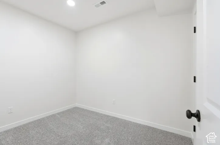 Bright room featuring light gray carpet, white baseboards, and recessed ceiling lighting