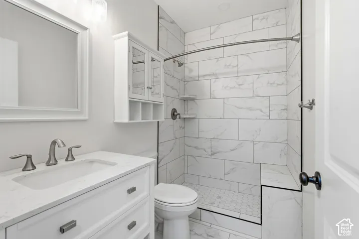 Bathroom featuring a white vanity with an integrated sink, brushed nickel faucet, and a framed mirror