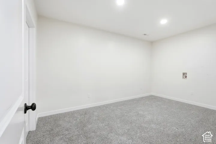 Versatile interior space featuring light gray carpeting, white baseboards, and neutral wall paint