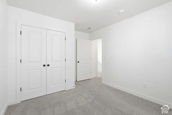 Room featuring light gray carpet, white walls, and white trim