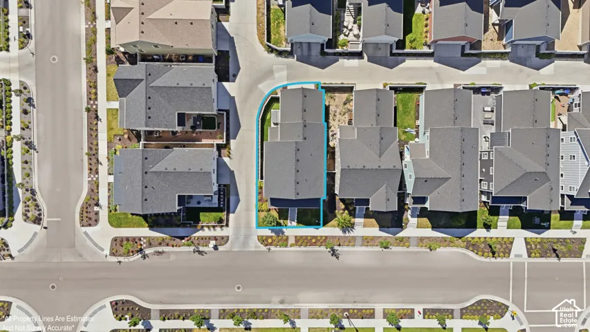 Aerial view of a residential property with a dark gray roof, situated on a corner lot