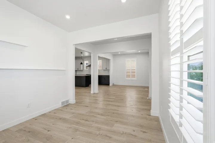 Open-concept interior featuring light wood-finish flooring, white walls, and recessed lighting