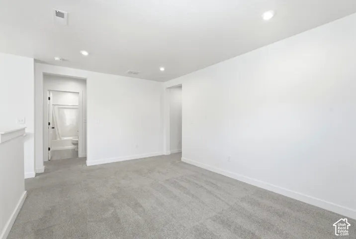 Carpeted room featuring recessed lighting, bright white walls, and white trim