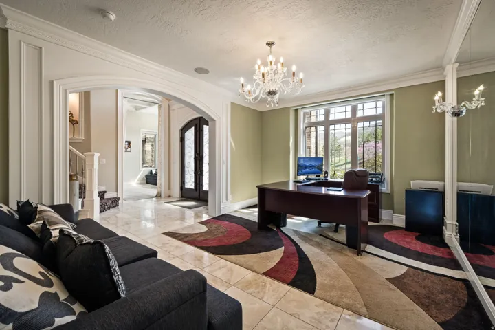 Home office featuring crown molding, suspended lighting, a textured ceiling, and arched walkways