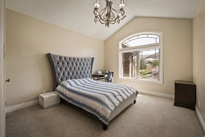 Bedroom featuring a chandelier, carpet floors, and a mountain view