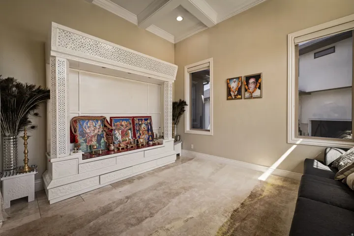 Living area featuring coffered ceiling, ornamental molding, and recessed lighting