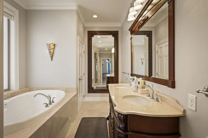 Full bathroom featuring double vanity, crown molding, a garden tub, recessed lighting, and light tile patterned flooring