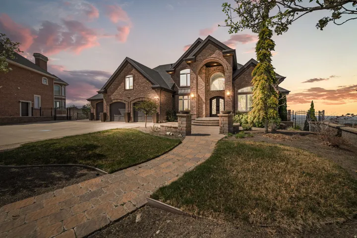 French country inspired facade with brick siding and concrete driveway
