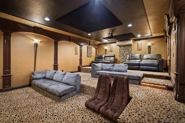 Cinema featuring a tray ceiling, recessed lighting, crown molding, ceiling fan, and decorative columns