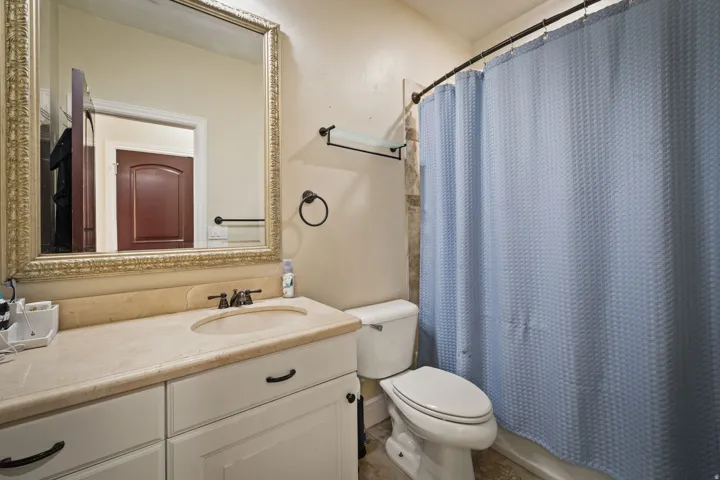 Full bathroom with curtained shower and vanity