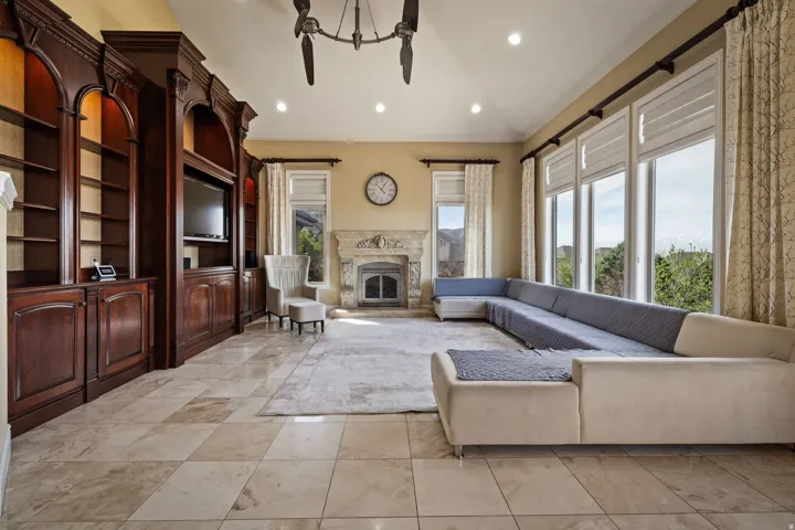 Living area featuring a premium fireplace, lofted ceiling, recessed lighting, and built in features