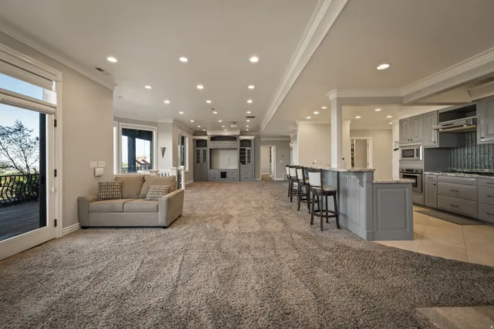 Living area featuring crown molding, light colored carpet, and recessed lighting