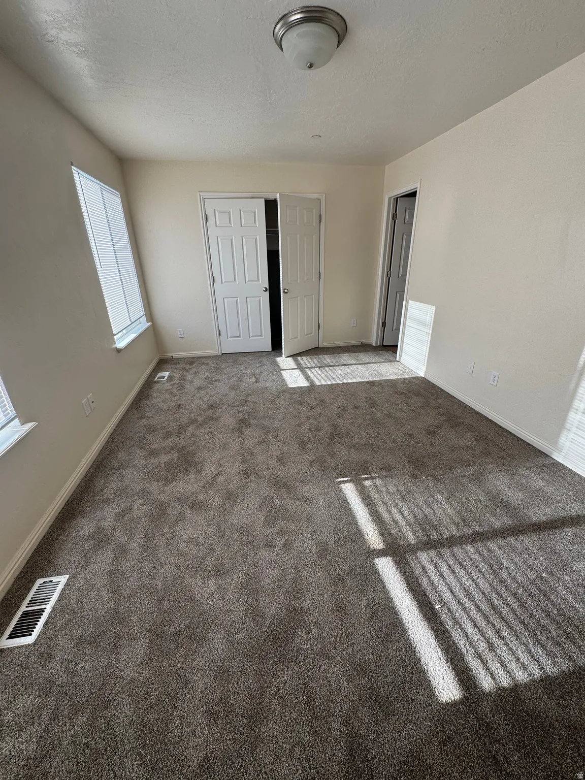 Unfurnished bedroom with carpet, a textured ceiling, and a closet