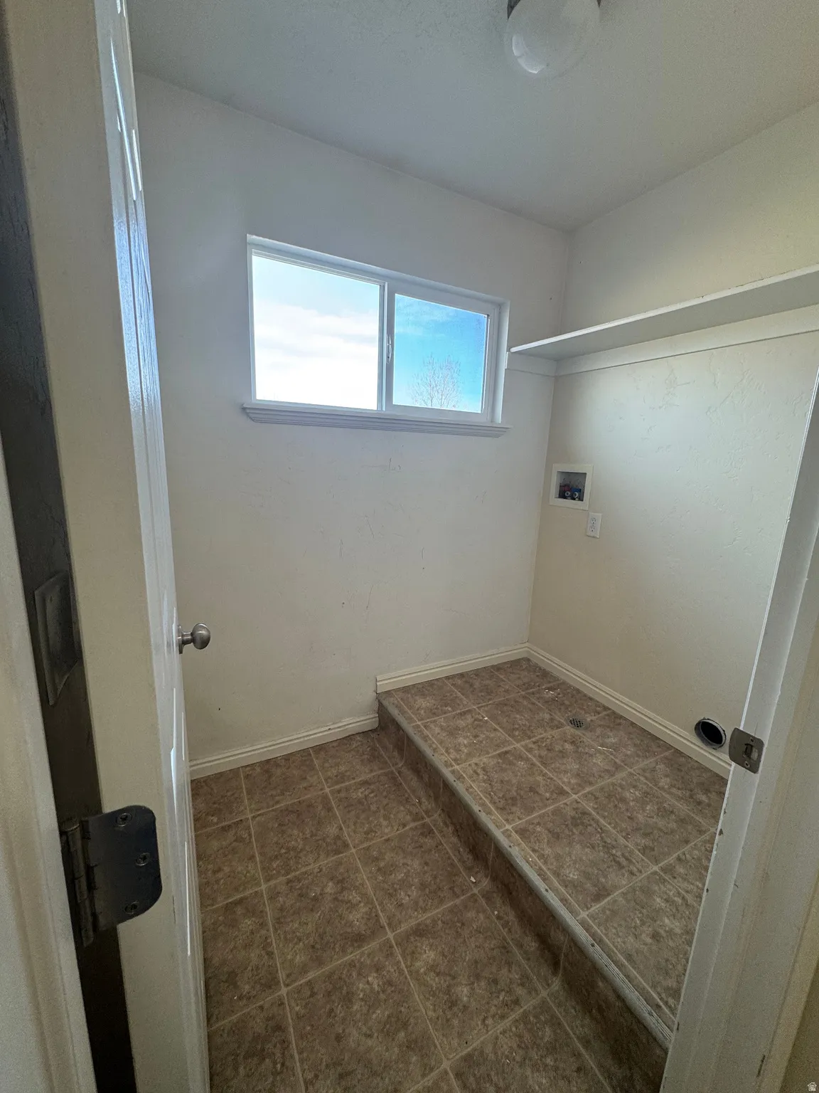 Laundry room featuring hookup for a washing machine and dark tile patterned floors
