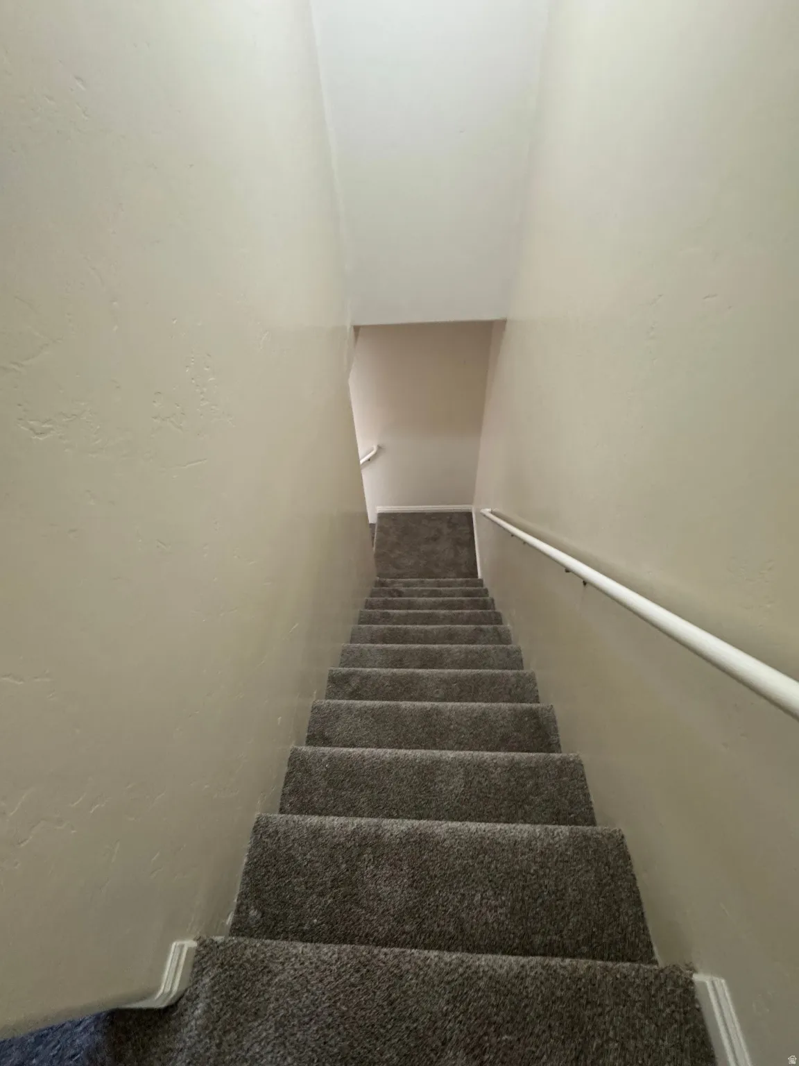 Stairway featuring a textured wall