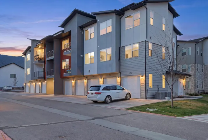 View of front of house with stucco siding, a garage, and driveway